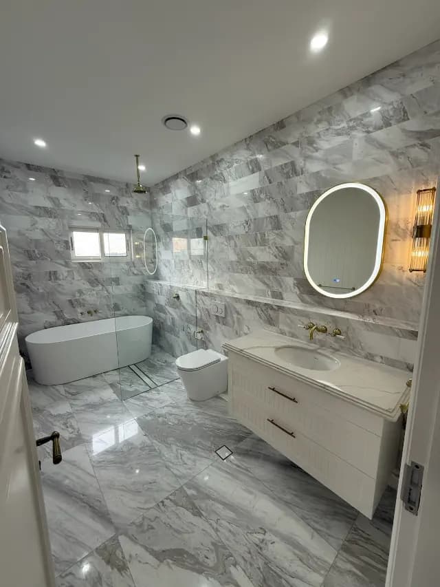 Completed marble-look bathroom with brass tapware